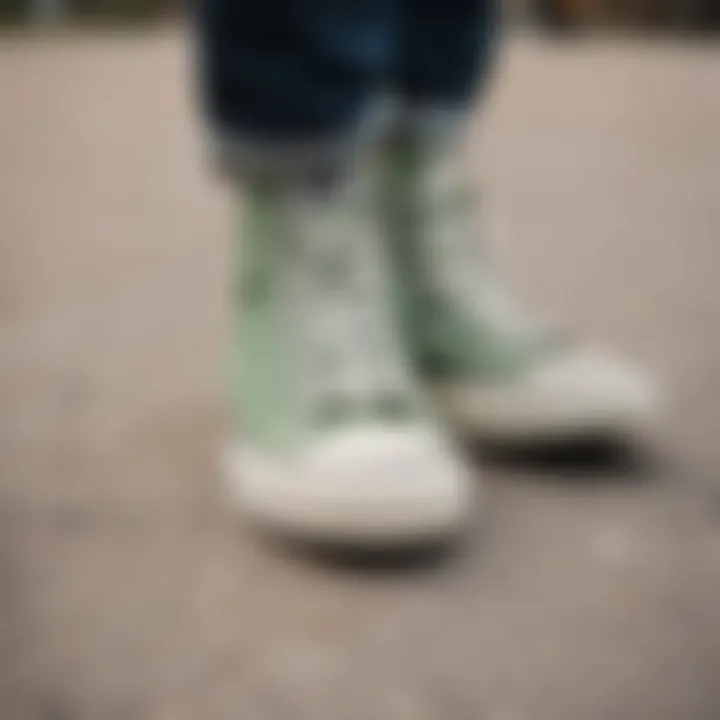 Close-up of sage green Converse shoes on a skateboard