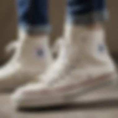 Close-up of white Chuck Taylor high tops showing wear and tear from skateboarding