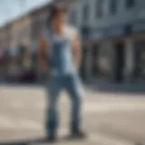 Stylish skater wearing light wash denim overalls in an urban setting