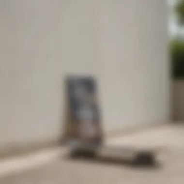 A serene outdoor scene where a skateboard rests against a wall, complementing a white graphic tee laid out nearby.